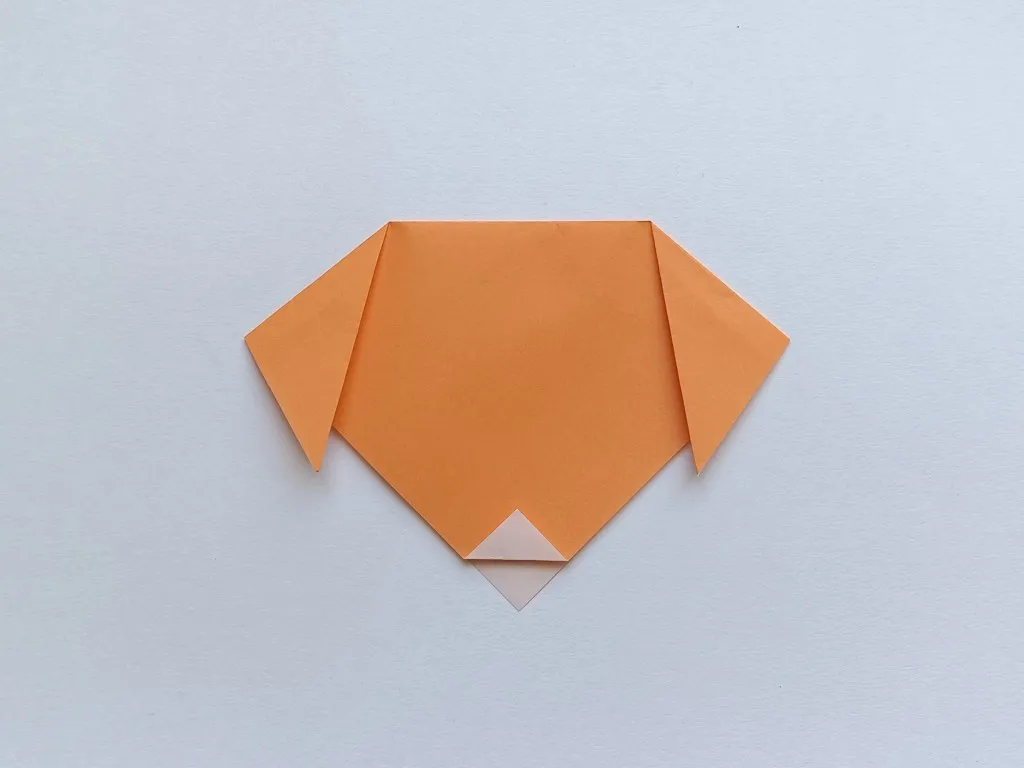 Fold the bottom tip up a little to make the dog's nose.