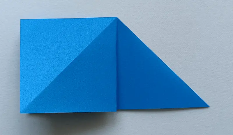 Put your finger in the top triangle, open it up, and flatten it