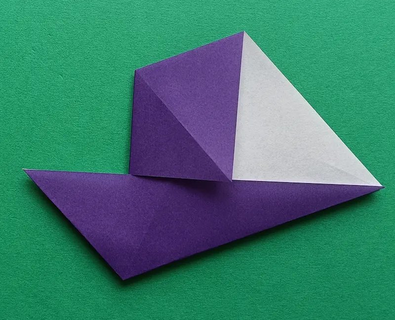 Put your finger in the bottom pocket, and fold it to meet the center crease