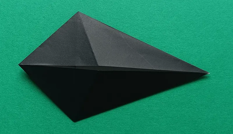 Put your finger in the top pocket, and fold it to meet the center crease